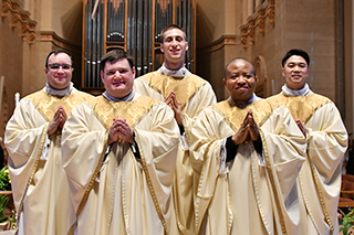 Newly ordained priests in vestments.